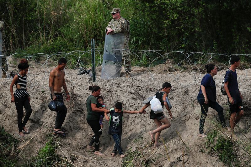 © Reuters. Migrants walk along the banks of the Rio Bravo river after crossing the border to turn themselves in to U.S. Border Patrol agents before the lifting of Title 42, as seen from Matamoros, Mexico May 11, 2023. REUTERS/Daniel Becerril