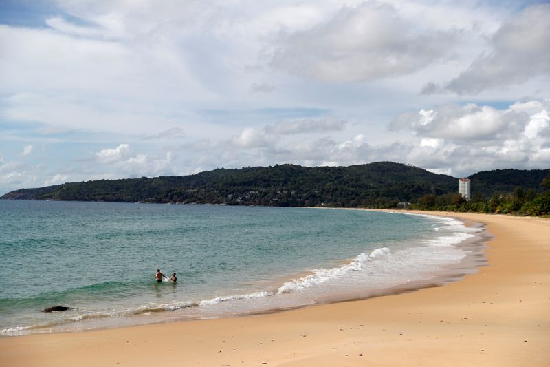 &copy; Reuters. FILE PHOTO: People are seen at an empty beach in Phuket, Thailand, March 31, 2021. REUTERS/Jorge Silva/File Photo