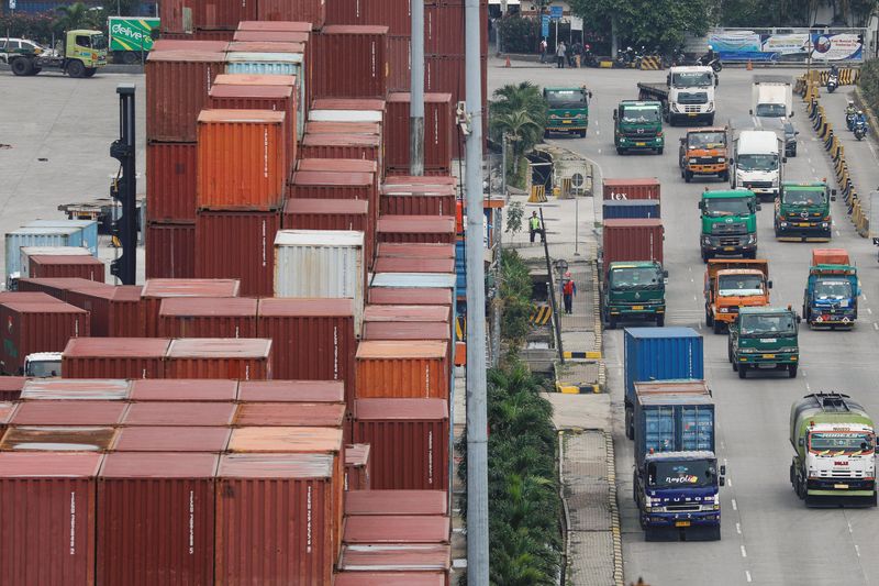 &copy; Reuters. FILE PHOTO: Trucks drive past stacks of containers at the Tanjung Priok port in Jakarta, Indonesia, February 3, 2023. REUTERS/Ajeng Dinar Ulfiana