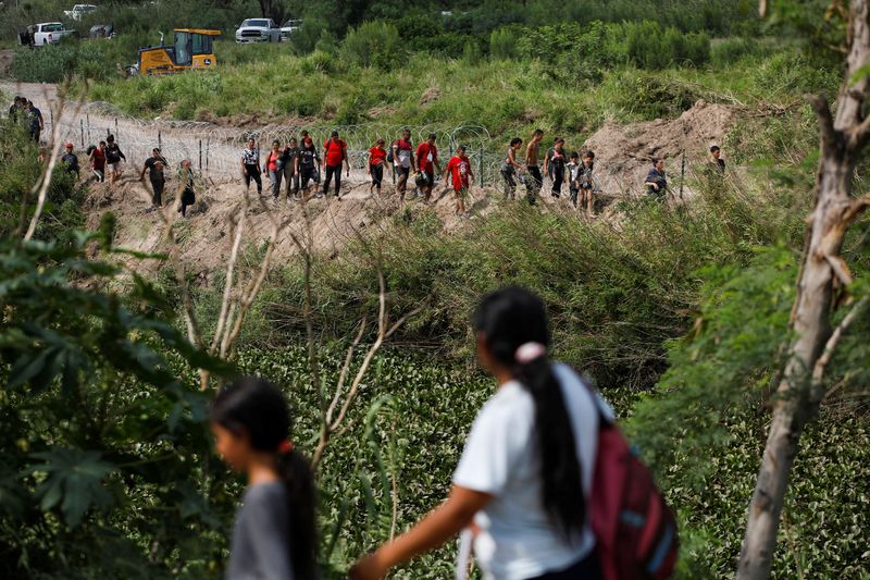 © Reuters. Migrants walk along the banks of the Rio Bravo river after crossing the border to turn themselves in to U.S. Border Patrol agents before the lifting of Title 42, as seen from Matamoros, Mexico, May 11, 2023. REUTERS/Daniel Becerril
