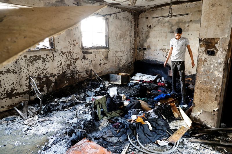 © Reuters. A man stands in a damaged building at the site of deadly Israeli raid in Balata camp in the Israeli-occupied West Bank May 13, 2023. REUTERS/Raneen Sawafta