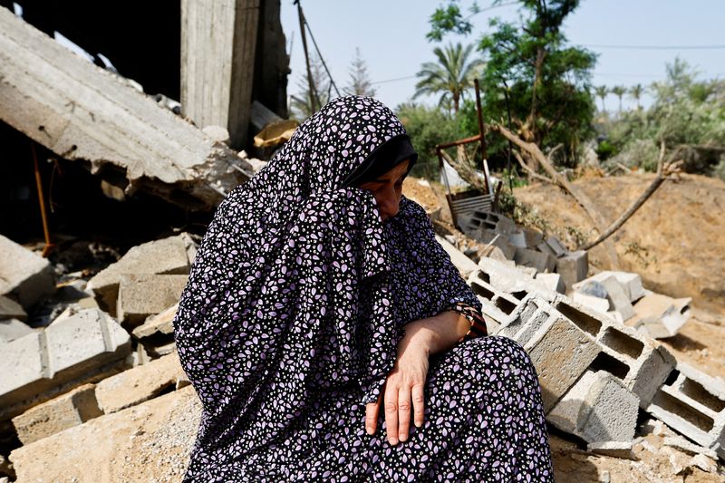 &copy; Reuters. سيدة فلسطينية تدعى فاطمة بشير تبكي بجوار أنقاض منزلها الذي دمرته غارة جوية إسرائيلية في منطقة دير البلح بوسط قطاع غزة يوم السبت . تصوير : إبر