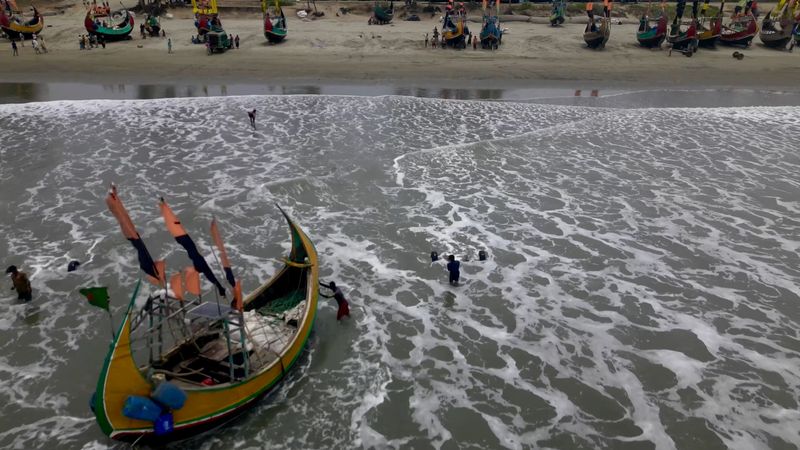 &copy; Reuters. منظر اُلتقط بطائرة مسيرة لصيادين يدفعون قواربهم إلى أماكن آمنة بسبب إعصار موكا في بنجلادش يوم 12 مايو أيار 2023 في لقطة من مقطع مصور حصلت عليه ر