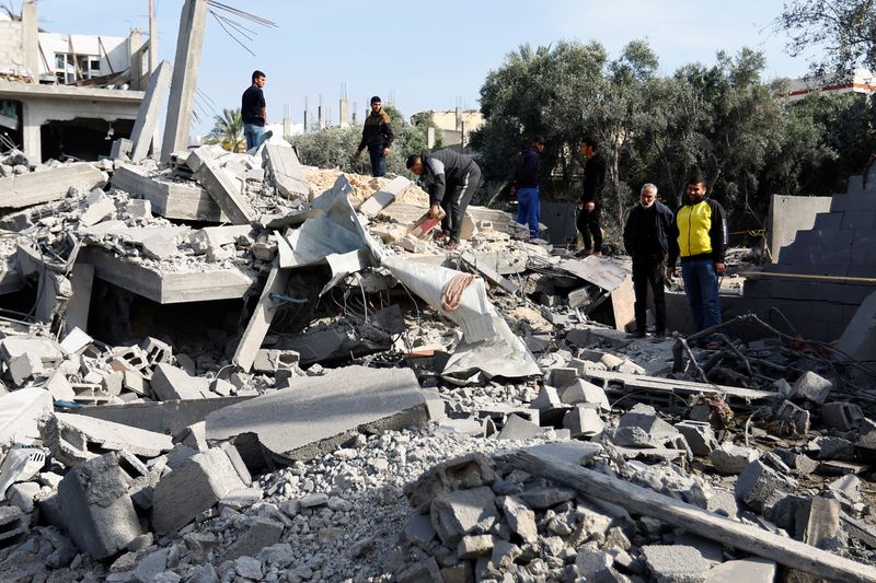 © Reuters. Palestinians stand on the remains of their destroyed houses, which were damaged in an Israeli strike during Israel-Gaza fighting, after a ceasefire was agreed between Palestinian factions and Israel, in Deir Al-Balah, central Gaza Strip May 14, 2023. REUTERS/Ibraheem Abu Mustafa