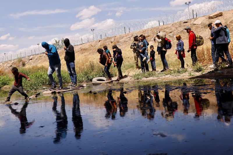 &copy; Reuters. Migrants seeking asylum cross the Rio Bravo river to return to Mexico from the United States, after members of the Texas Army National Guard extend razor wire to inhibit migrants from crossing, as seen from Ciudad Juarez, Mexico May 13, 2023. REUTERS/Jose