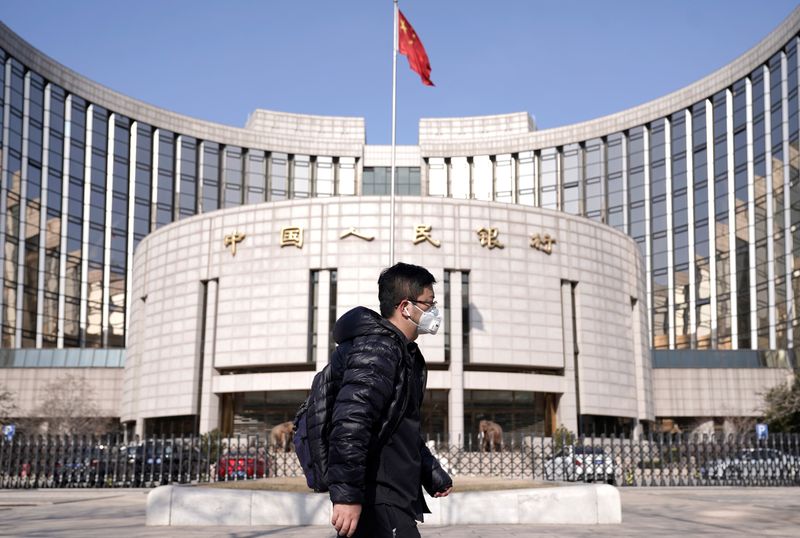 &copy; Reuters. FILE PHOTO: A man wearing a mask walks past the headquarters of the People's Bank of China, the central bank, in Beijing, China, as the country is hit by an outbreak of the new coronavirus, February 3, 2020. REUTERS/Jason Lee