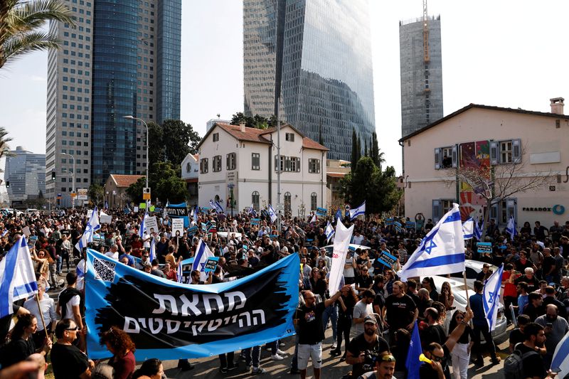 &copy; Reuters. FILE PHOTO: Israelis working in the hi-tech sector hold the national flag of Israel and a banner with the Hebrew words "The hi-tech protest" as they demonstrate against proposed judicial reforms by Israel's new right-wing government in Tel Aviv, Israel Ja