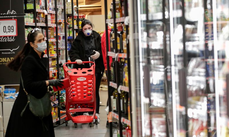 © Reuters. FILE PHOTO: People wearing protective face masks are seen in a supermarket in Posillipo, near Naples, Italy, March 10, 2020. REUTERS/Ciro De Luca