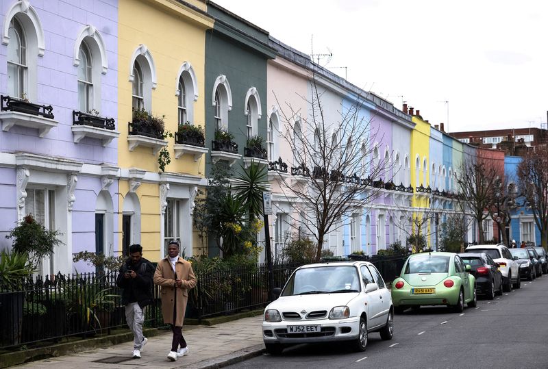 &copy; Reuters. FILE PHOTO: People walk past a row of colourful houses in London, Britain, March 19, 2023. REUTERS/Henry Nicholls