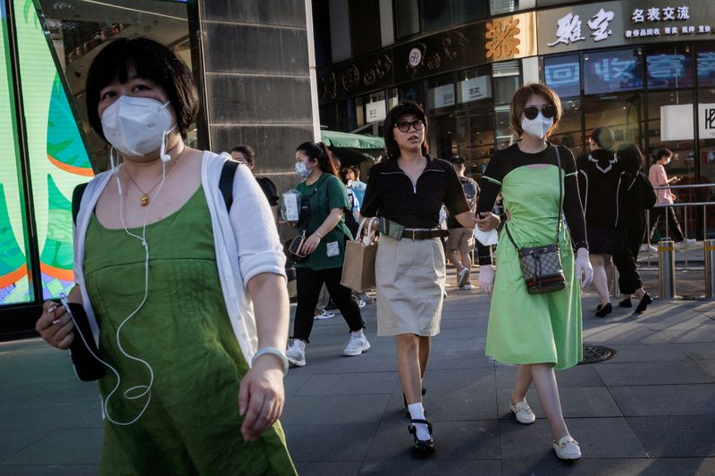 © Reuters. FILE PHOTO: Shoppers walk in a retail district in Beijing, China, July 13, 2022.  REUTERS/Thomas Peter/File Photo