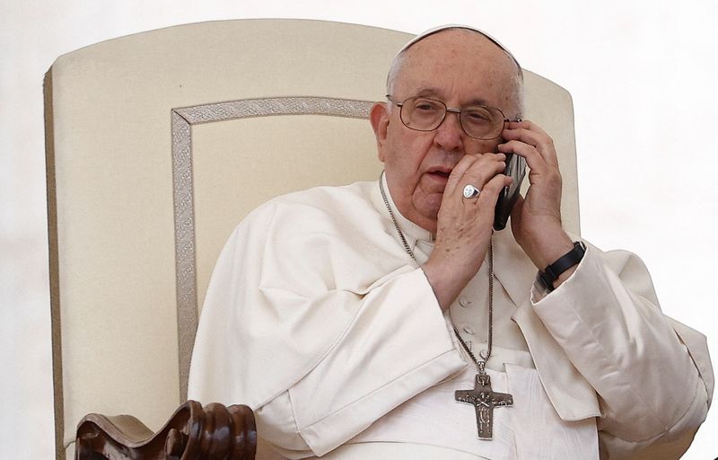 &copy; Reuters. Pope Francis speaks on the phone during the weekly general audience in St. Peter's Square at the Vatican, May 17, 2023. REUTERS/Guglielmo Mangiapane