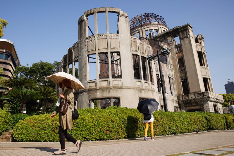 &copy; Reuters. Persone cammina davanti alla cupola commemorativa del Peace Memorial Park, prima del vertice del G7  ad Hiroshima. 17 maggio 2023. REUTERS/Androniki Christodoulou