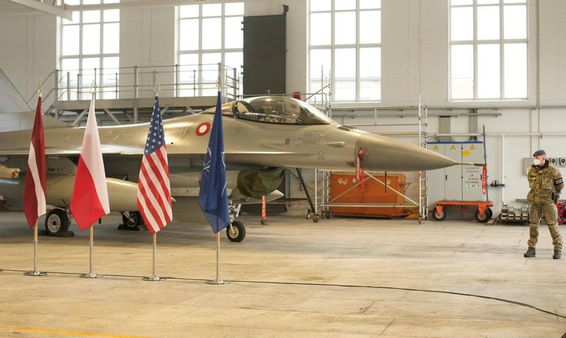 &copy; Reuters. Danish Royal Air Force fighter F-16, arrived as part of enforced air poling mission, is seen in front of the flags of Latvia, Poland, the USA and NATO, during a welcome ceremony in Siauliai military air base, Lithuania January 28, 2022. REUTERS/Ints Kalni