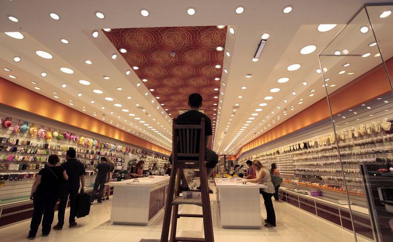 &copy; Reuters. FILE PHOTO: A security guard stands guard on the top of a chair as consumers shop in a store in downton Sao Paulo  November 19, 2014. REUTERS/Paulo Whitaker 