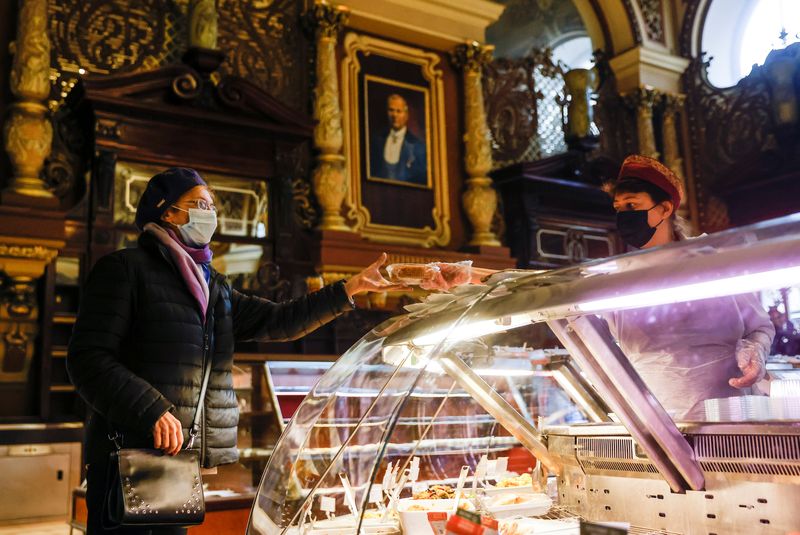 &copy; Reuters. FILE PHOTO: A woman wearing a protective face mask makes a purchase at Yeliseyevsky Store in central Moscow, Russia April 2, 2021. Picture taken April 2, 2021. REUTERS/Maxim Shemetov