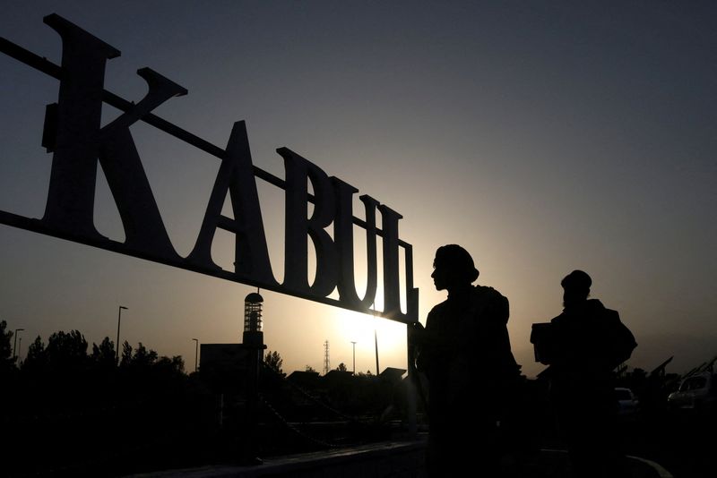 © Reuters. FILE PHOTO: Taliban soldiers stand in front of a sign at the international airport in Kabul, Afghanistan, September 9, 2021. WANA (West Asia News Agency) via REUTERS/File Photo