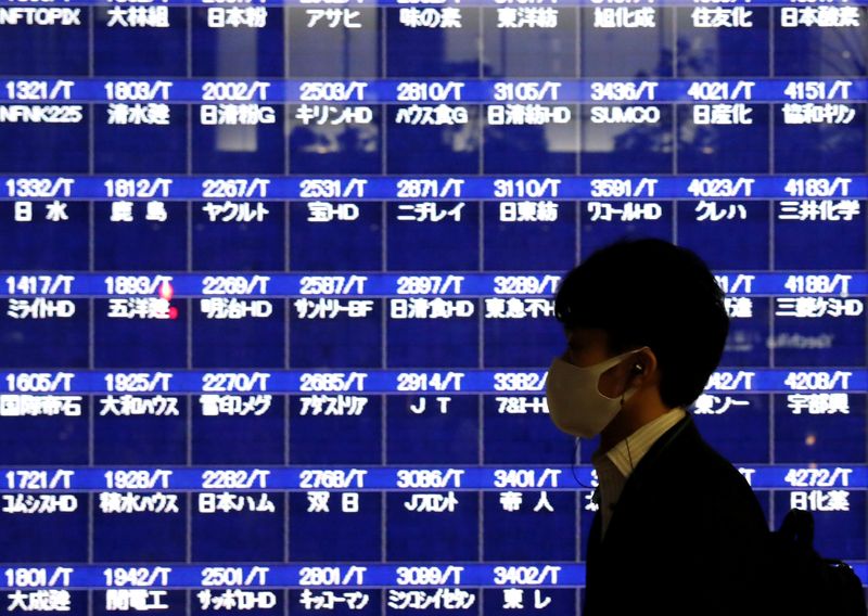 &copy; Reuters. أحد المارة قرب شاشة إلكترونية تعرض أسعار الأسهم في طوكيو في صورة من أرشيف رويترز.