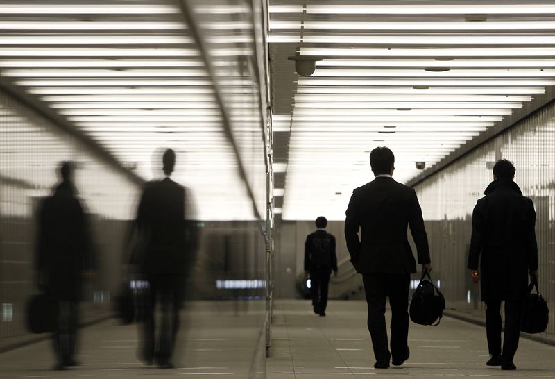 © Reuters. Businessmen walk through a business complex in Tokyo January 11, 2011. REUTERS/Yuriko Nakao 