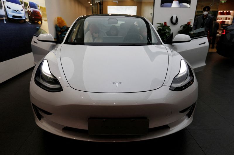 © Reuters. FILE PHOTO: Visitors check a Tesla Model 3 car at a showroom of the U.S. electric vehicle (EV) maker in Beijing, China February 4, 2023. REUTERS/Florence Lo