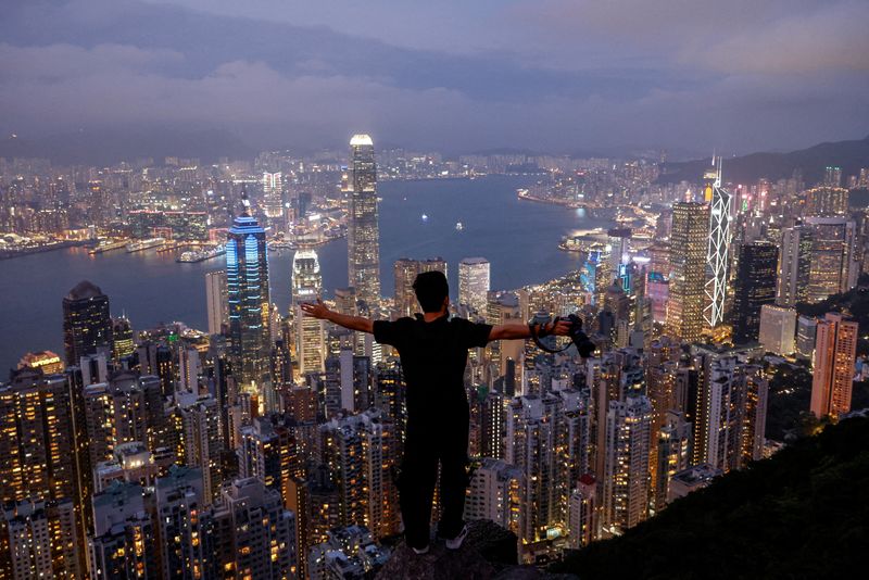 &copy; Reuters. FILE PHOTO: A tourist poses for a photo against the backdrop of the financial Central district and Victoria Harbour in Hong Kong, China, May 9, 2023. REUTERS/Tyrone Siu