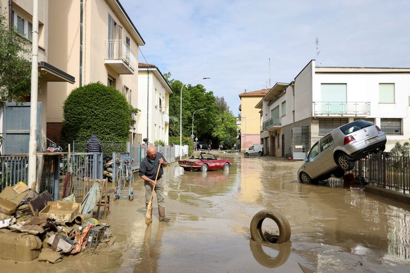© Reuters. A resident removes mud and debris after heavy rains hit Italy's Emilia Romagna region, in Faenza, Italy, May 18, 2023. REUTERS/Claudia Greco     
