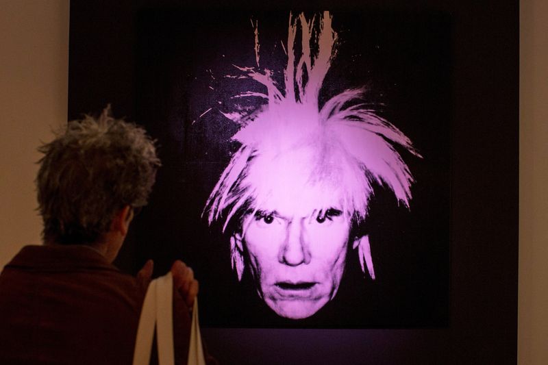 &copy; Reuters. FOTO DE ARCHIVO. Un hombre examina "Autorretrato" de Andy Warhol durante un avance para los medios en la casa de subastas Christie's en Nueva York, EEUU, el 31 de octubre de 2014. REUTERS/Brendan McDermid