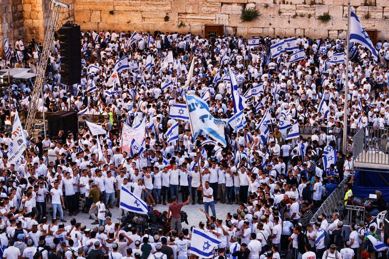 © Reuters. إسرائيليون يرفعون الأعلام في البلدة القديمة بالقدس يوم الخميس. تصوير: رونن زفولن - رويترز. 