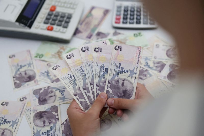 &copy; Reuters. سيدة تحمل في يديها أوراقا نقدية من عملة الليرة التركية في هذه الصورة التوضيحية التي التقطت يوم 30 مايو أيار 2022. تصوير: دادو روفيتش - رويترز 