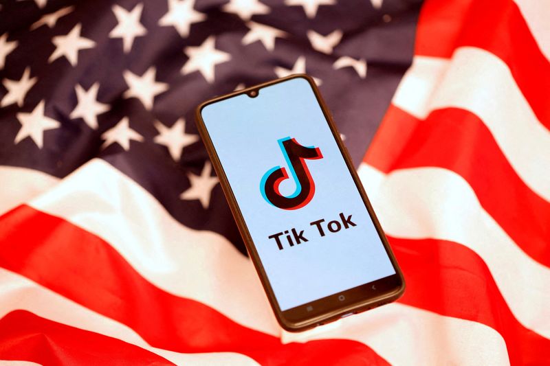 © Reuters. FILE PHOTO: FTikTok logo is displayed on the smartphone while standing on the U.S. flag in this illustration picture taken, November 8, 2019. REUTERS/Dado Ruvic/File Photo