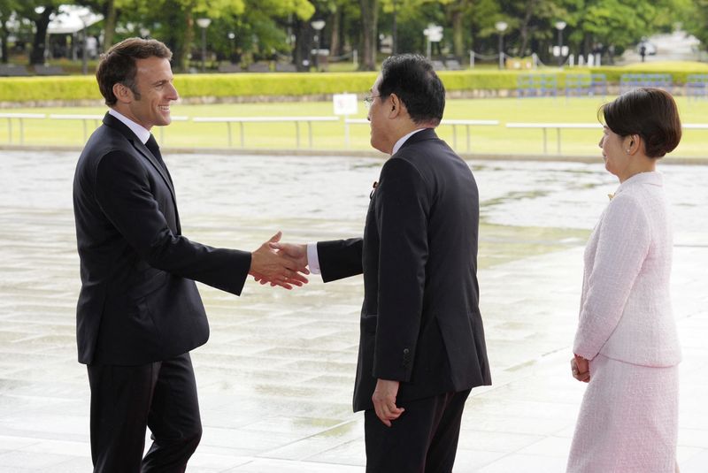 &copy; Reuters. Le président français Emmanuel Macron est accueilli par le Premier ministre japonais Fumio Kishida et son épouse Yuko Kishida au Parc commémoratif de la paix lors d'une visite dans le cadre du sommet du G7 d'Hiroshima, à Hiroshima, au Japon. /Photo p