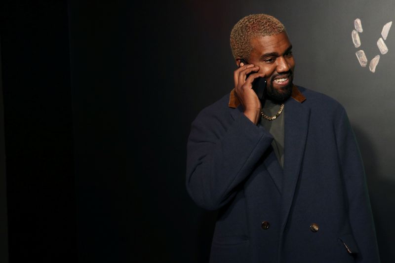 © Reuters. FILE PHOTO: Rapper Kanye West talks on the phone before attending the Versace presentation in New York, U.S. December 2, 2018. REUTERS/Allison Joyce