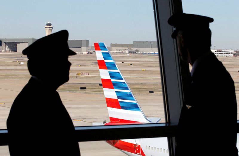 &copy; Reuters. FILE PHOTO: Pilots talk as they look at the tail of an American Airlines aircraft at Dallas-Ft Worth International Airport February 14, 2013. REUTERS/Mike Stone