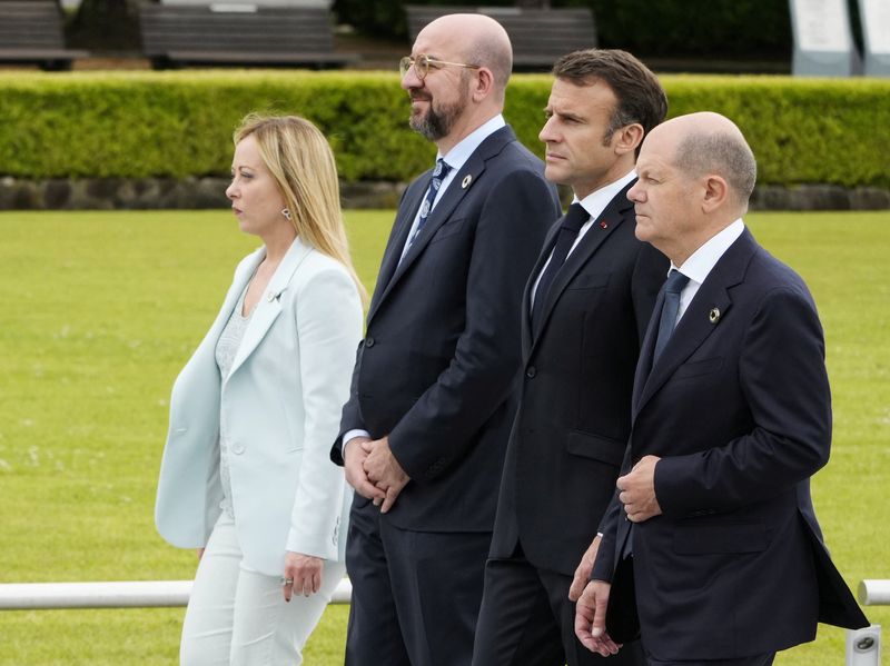 © Reuters. Italian Prime Minister Giorgia Meloni, European Council President Charles Michel, French President Emmanuel Macron, and German Chancellor Olaf Scholz  walk to a flower wreath laying ceremony at the Cenotaph for Atomic Bomb Victims in the Peace Memorial Park as part of the G7 Hiroshima Summit in Hiroshima, Japan, 19  May 2023. The G7 Hiroshima Summit will be held from 19 to 21 May 2023.    