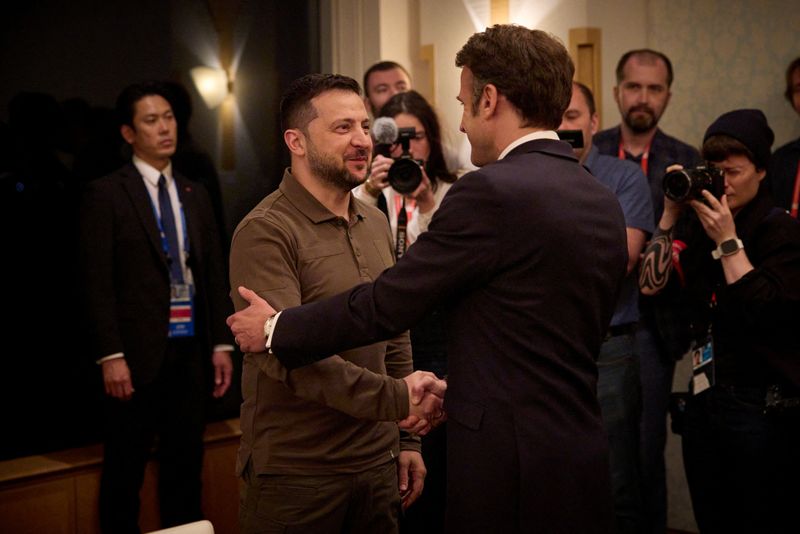 &copy; Reuters. Ukraine's President Volodymyr Zelenskiy and French President Emmanuel Macron shake hands during the G7 leaders' summit in Hiroshima, Japan May 20, 2023.  Ukrainian Presidential Press Service/Handout via REUTERS 