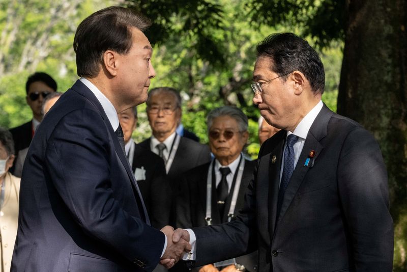 &copy; Reuters. رئيس كوريا الجنوبية يون سوك يول يصافح رئيس الوزراء الياباني فوميو كيشيدا خلال زيارة النصب التذكاري للضحايا الكوريين للقنبلة الذرية بالقرب 