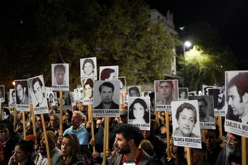 © Reuters. People hold photographs during the 