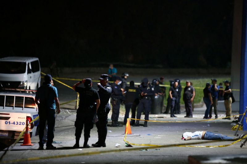 &copy; Reuters. MATERIAL SENSÍVEL. ESTA IMAGEM PODE OFENDER OU PERTURBAR Policiais perto do corpo de um torcedor que foi morto em um tumulto antes de um jogo de futebol entre C.D. FAS vs. Aliança F.C. no estádio Cuzcatlan, em San Salvador, El Salvador, 20 de maio de 2