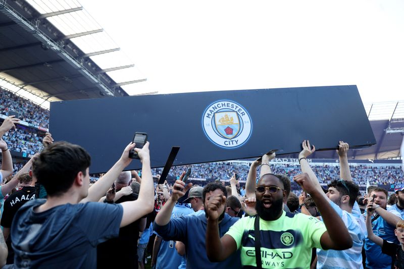 &copy; Reuters. Soccer Football - Premier League - Manchester City v Chelsea - Etihad Stadium, Manchester, Britain - May 21, 2023 Manchester City fans celebrate on the pitch after winning the Premier League REUTERS/Carl Recine EDITORIAL USE ONLY. No use with unauthorized