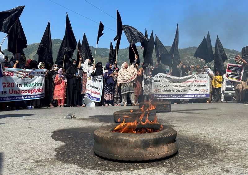 &copy; Reuters. People carry black flags and set tyres ablaze to condemn India's decision to host the G20 Tourism Working Group meeting in Srinagar, during a protest in Muzaffarabad, Pakistan-administrated Kashmir, May 22, 2023. REUTERS/Stringer 