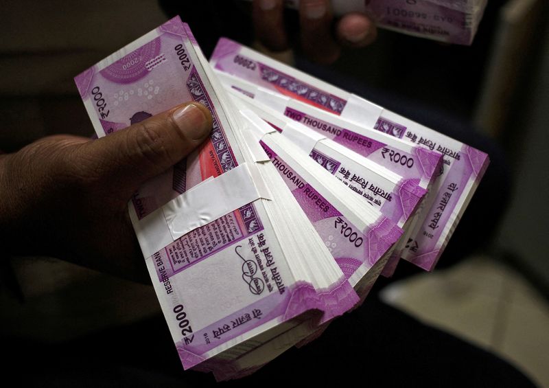 &copy; Reuters. FILE PHOTO: A cashier displays 2000 Indian rupee banknotes inside a bank in Jammu, November 15, 2016. REUTERS/Mukesh Gupta