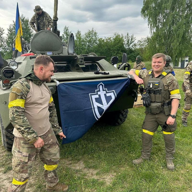 © Reuters. Members of Russian Volunteer Corps stand next to an armoured vehicle in this undated  handout picture obtained by Reuters on May 23, 2023.  Russian Volunteer Corps/Handout via REUTERS