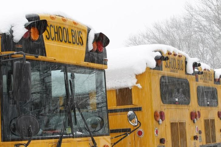 © Reuters. Snow falls over school buses parked at Great Falls Elementary School in Great Falls, Virginia, just outside of Washington, DC, January 28, 2011.    REUTERS/Hyungwon Kang   