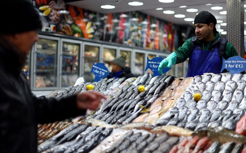 &copy; Reuters. Photo d'archives: Un employé sert des clients dans une poissonnerie au Lewisham Market, dans le sud-est de Londres, en Grande-Bretagne. /Photo prise le 9 mars 2023/REUTERS/Hannah McKay 