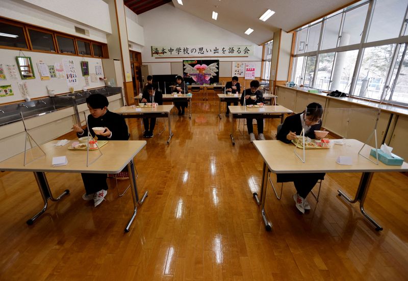 &copy; Reuters. FILE PHOTO: Eita Sato, 15, and Aoi Hoshi, 15, the only two students at Yumoto Junior High School, have their last school lunch with their teachers before their graduation and the institution's closing ceremony, Fukushima Prefecture, Japan, March 9, 2023. 