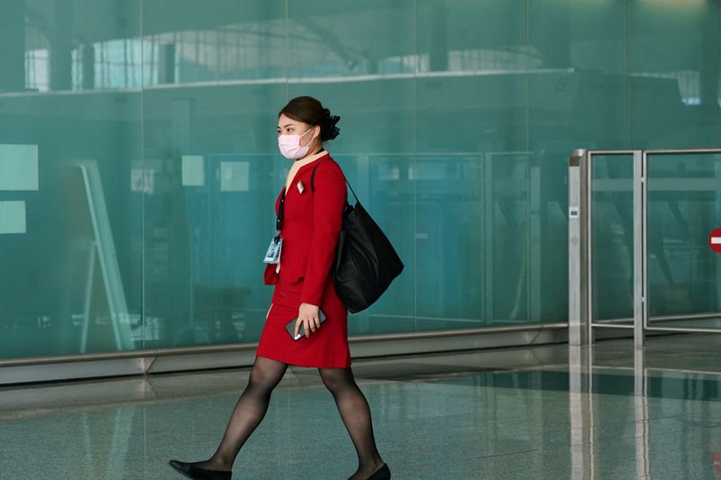 © Reuters. FILE PHOTO: A Cathay Pacific employee, wearing a face mask following the coronavirus disease (COVID-19) outbreak, walks past the departures hall at Hong Kong International Airport in Hong Kong, China October 20, 2020. REUTERS/Lam Yik/File Photo