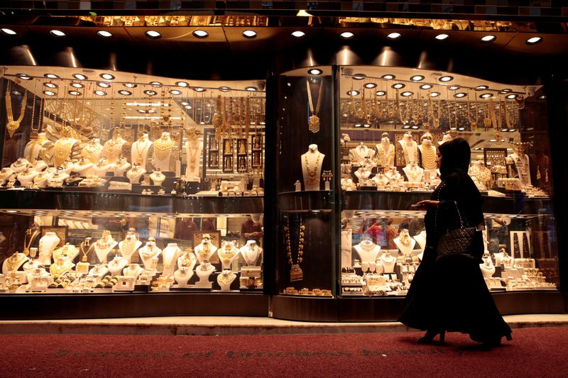 &copy; Reuters. FILE PHOTO: A woman walks past gold jewellery displayed in a shop window at the Gold Souq in Dubai, United Arab Emirates March 24, 2018. REUTERS/Christopher Pike/File Photo