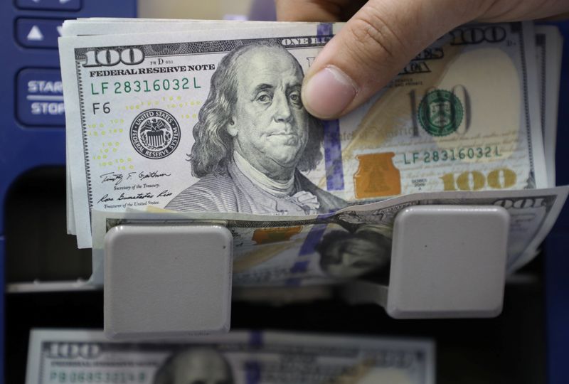 &copy; Reuters. Un hombre cuenta billetes de dólares estadounidenses en una tienda de cambio de divisas en Beirut, Líbano,