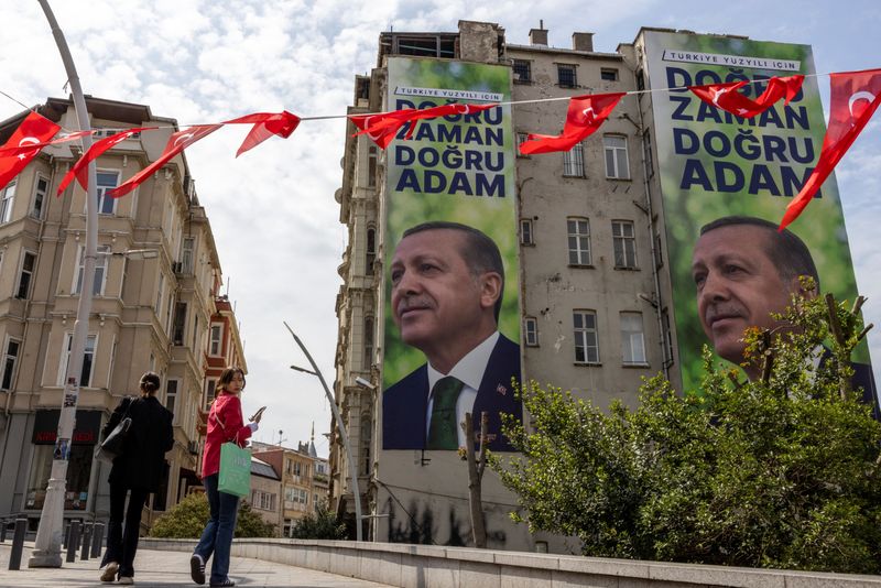 &copy; Reuters. People walk next to posters of Turkish President Tayyip Erdogan, ahead of the May 28 presidential runoff vote, in Istanbul, Turkey, May 25, 2023. REUTERS/Umit Bektas