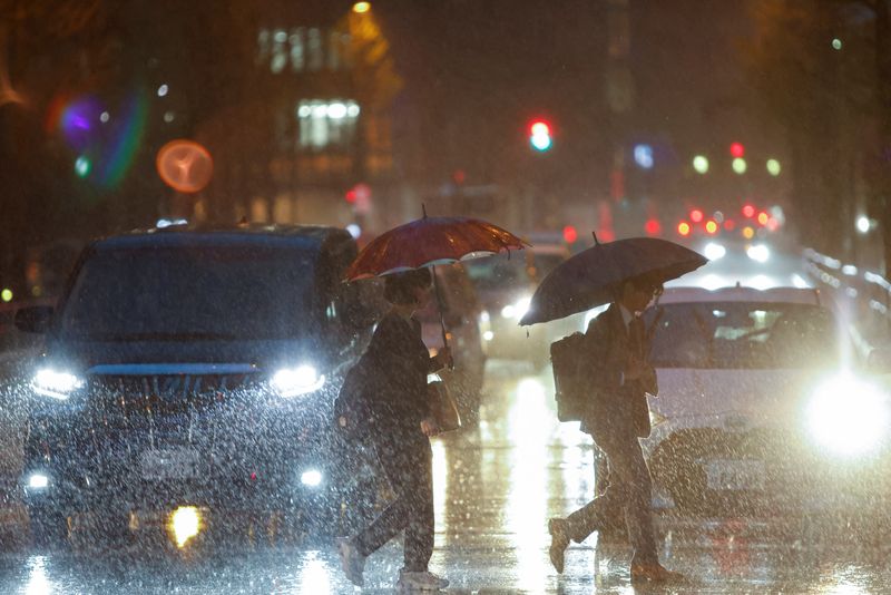 &copy; Reuters. FILE PHOTO: Office employees cross the street under pouring rain at a business area in Tokyo, Japan, April 7, 2023. REUTERS/Androniki Christodoulou