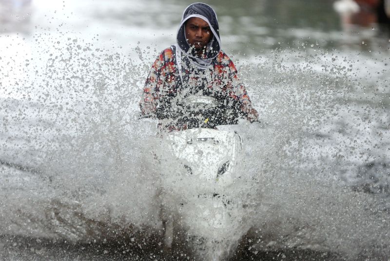 &copy; Reuters. Motoqueiro anda em meio às águas das chuvas de monção em Mumbai. REUTERS/Francis Mascarenhas